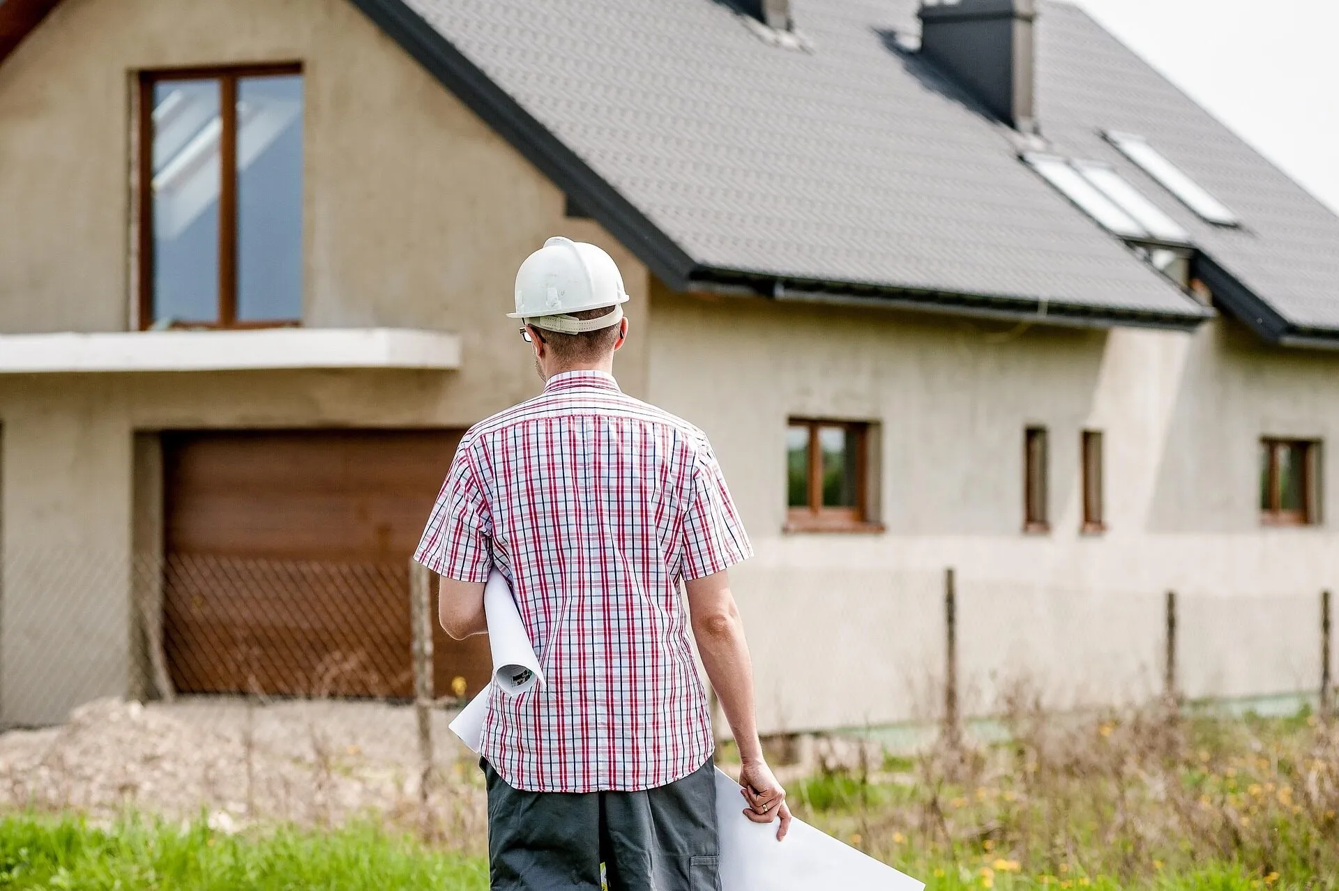 Builder with architectural plans inspecting a building project - getting quotes from qualified Dublin builders
